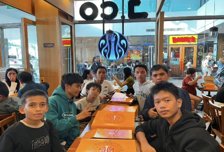 Students seated at restaurant tables, looking towards the camera.